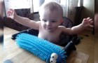  A baby touches a puffer caterpillar toy and is frightened in an adorable way