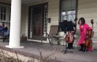 Dos niños tocan el violoncelo en el patio de una vecina anciana, para hacerle compañía mientras se encuentra en aislamiento