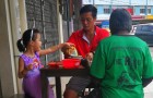 Um pai e sua filha convidam um sem-teto faminto para comer na mesa com eles