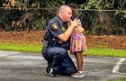 Politieagent knielt neer om een ​​klein meisje gerust te stellen dat getuige was van de arrestatie van haar stiefvader
