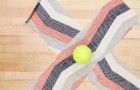 Ze vormt een 'X' van twee stroken van een oud t-shirt... als ze er een tennisbal in verwerkt, is het spelen geblazen!