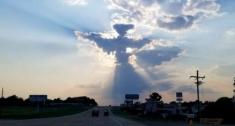 Um homem pega o celular e filma um anjo entre as nuvens 