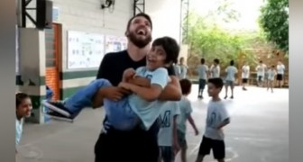 A physical education teacher picks up his disabled student to allow him to experience jumping rope