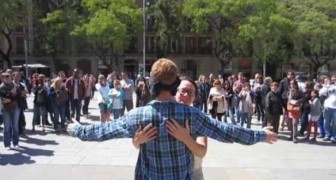 En man står på gatan och efterfrågar kramar och bjuder på en osannoliks show.