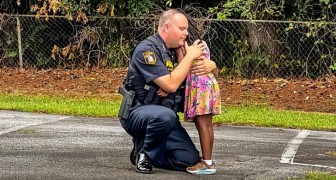 En polis går ner på knä för att trösta en flicka som just sett sin styvpappa bli arresterad