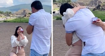Mädchen macht ihrem Freund einen Heiratsantrag, kniend in der Öffentlichkeit: Beifall folgt