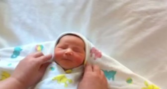 She wraps this cute baby in a blanket: his reaction at the end is adorable.