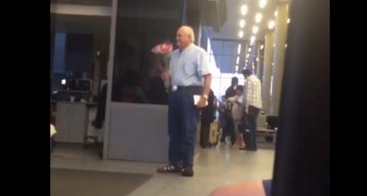 Um homem idoso espera sua amada no aeroporto com um buquê de flores: isso sim que é amor!