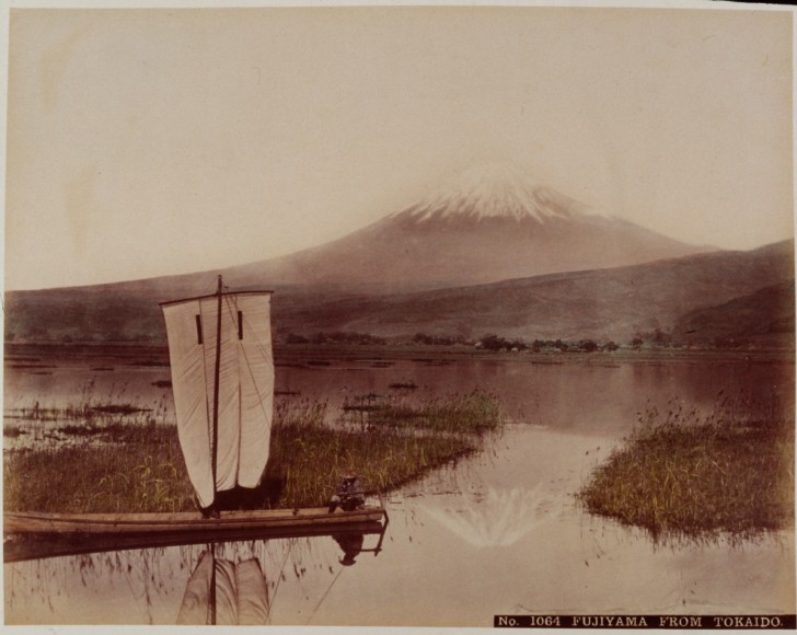 Een man in z'n bootje met de Fuji-berg op de achtergrond rond het jaar 1890