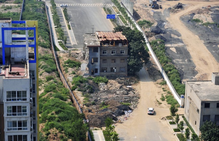 7. Parzialmente demolita e nel bel mezzo di una strada a Xi'an quest'abitazione sta resistendo (foto del 14 agosto 2013)...