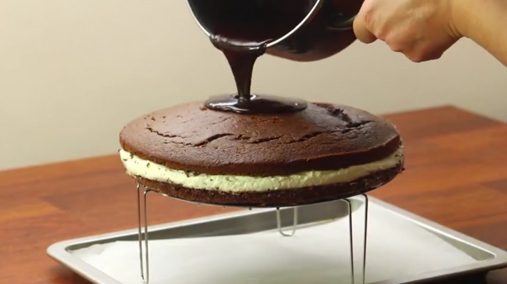 Sistemate una griglia rialzata su una teglia da forno: poggiateci la torta sopra ed iniziate a colare la glassa al cioccolato.