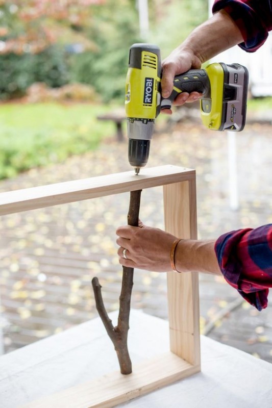 Fix the branches inside the frame by first drilling a hole and finish by inserting a screw.