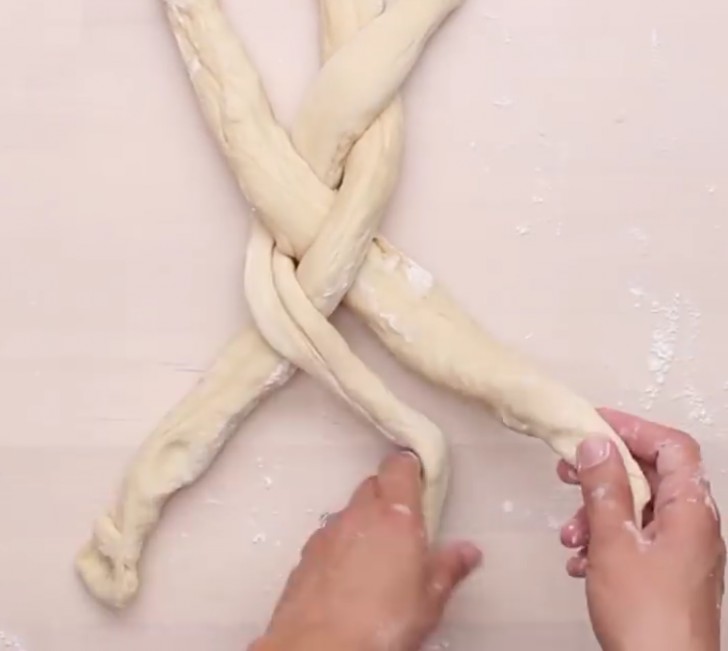 Remove the dough from the plastic bag and start kneading it with your hands. Then divide the dough into three parts which you will use to form a braid.