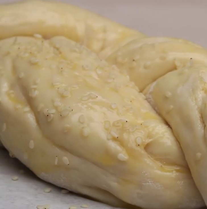 Seal the ends, brush egg on the surface of the dough and add the sesame seeds.