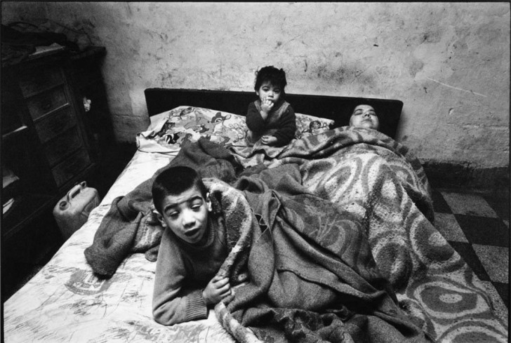 La donna ed i suoi bambini stanno sempre a letto. In casa non ci sono nè luce nè acqua, Palermo, 1978.