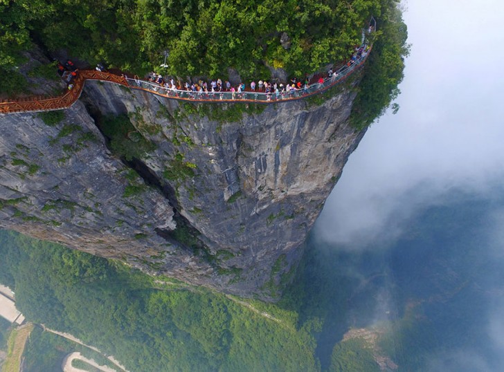 Een grote groep mensen loopt over het toeristisch platform van Zhangjiajie in de Hunanprovincie in China op 1 augustus 2016