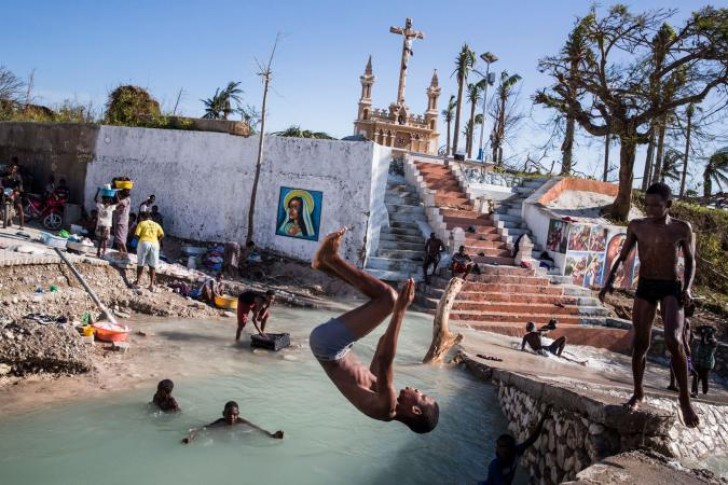 8. Dei ragazzi fanno il bagno nel punto in cui un ponte è crollato dopo il terribile uragano che ha colpito Haiti nell'ottobre del 2016.