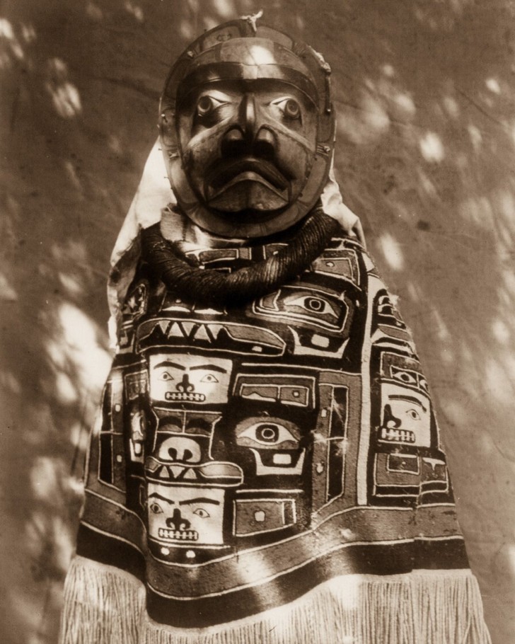 4. Une femme Qagyuhl porte une couverture à franges traditionnelle et un masque, pour célébrer un chaman défunt, 1914