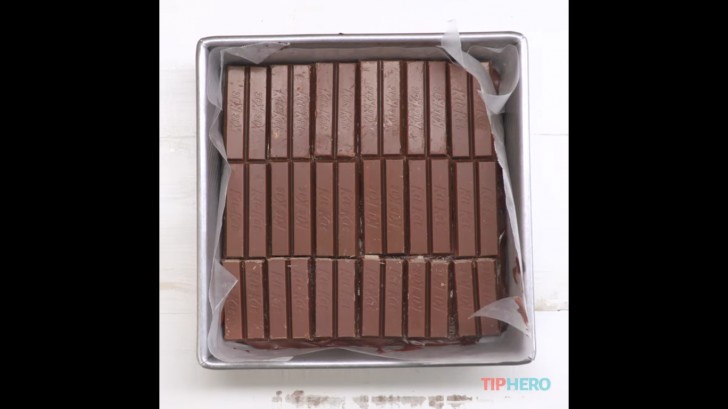 3. Extender sobre el molde parte de la crema al chocolate y posicionalo sobre las barritas de Kit Kat.