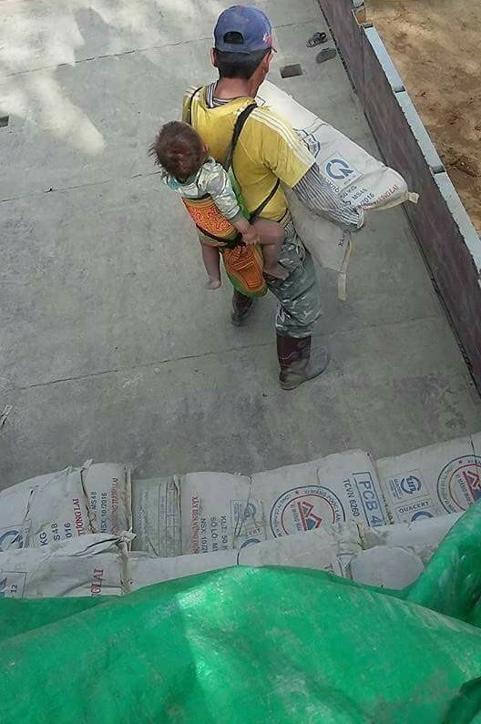 L'uomo, di cui non si sa il nome, ha deciso di prendersi cura del figlio anche durante il lavoro.