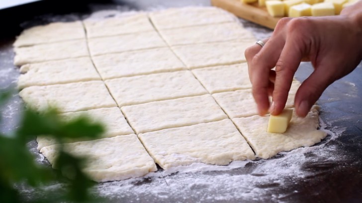 5. Stendete la pasta e tagliatela in quadratini: al centro di ognuno posizionate un pezzo di mozzarella e formate delle palline.