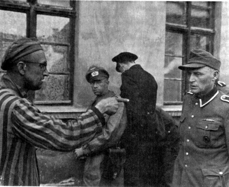 4. Un ex prisionero ruso del campo de Buchenwald colabora con las tropas estadounidenses en el proceso de identificacion de las guardias nazistas.