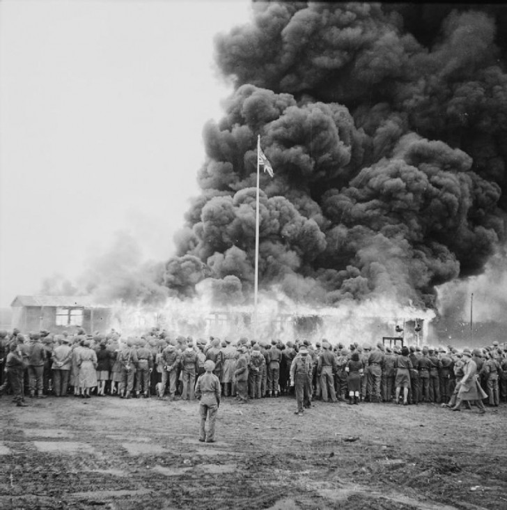 8. La multitud se reune en el momento en que las tropas britanicas dan fuego a la estructura del campo de Bergen-Belsen.