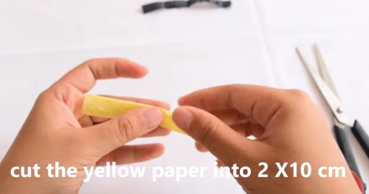 5. Passate agli altri colori: ritagliate una striscia di colore giallo larga 2 cm e lunga 10; piegatela a metà seguendo la lunghezza e ripiegate poi la striscia due volte (vedere video).