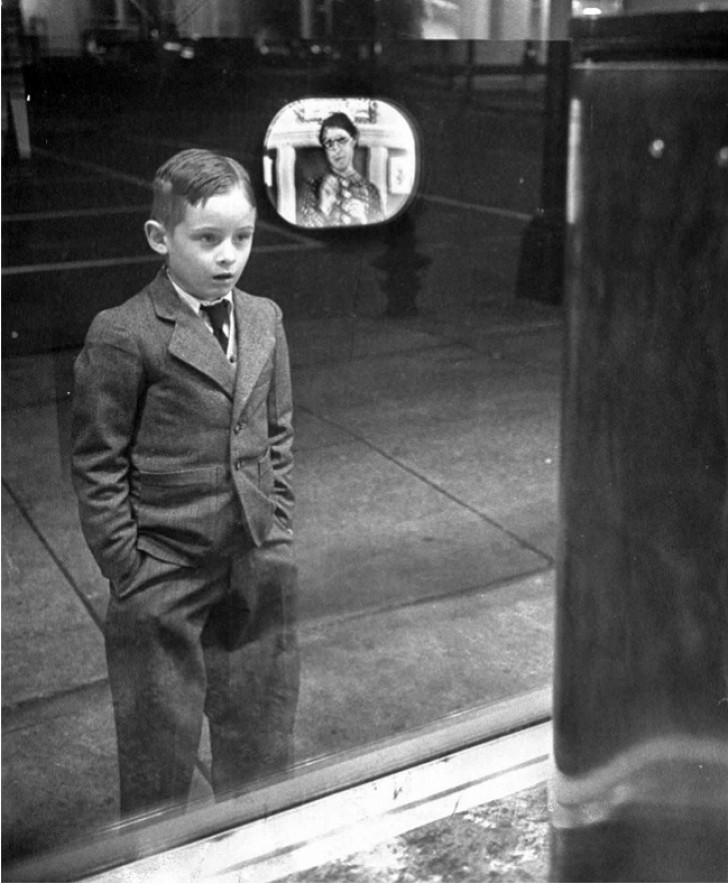 Un bambino guarda per la prima volta una televisione dalla vetrina di un negozio, nel 1948.