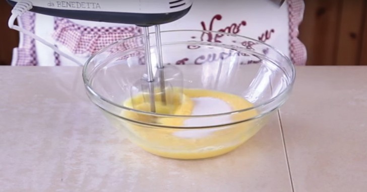 2. In una ciotola unite le due uova allo zucchero, amalgamando bene. In seguito aggiungete l'olio di semi (in questo caso sono di girasole) e l'acqua.