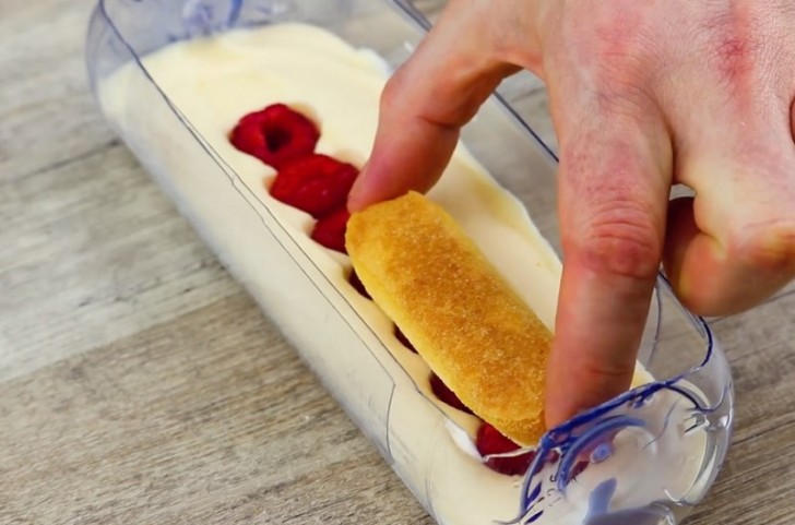 Dip the ladyfinger cookies briefly into the liquid coffee and place them on top of the raspberries.