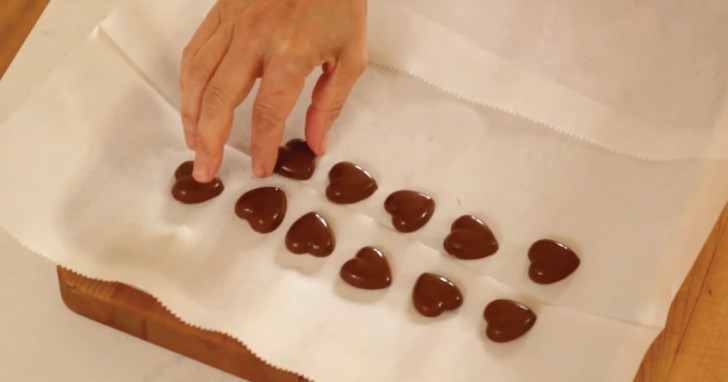 Ponete gli stampini nel freezer per almeno 5 minuti e poi rimuovete i cioccolatini a forma di cuore ormai solidi.