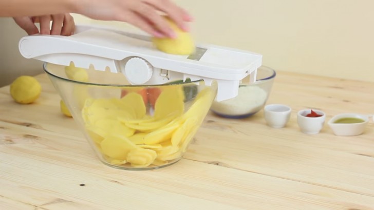 1. Sbucciate e tagliate le patate a fettine sottili: vi consigliamo l'uso di un'affettatrice.