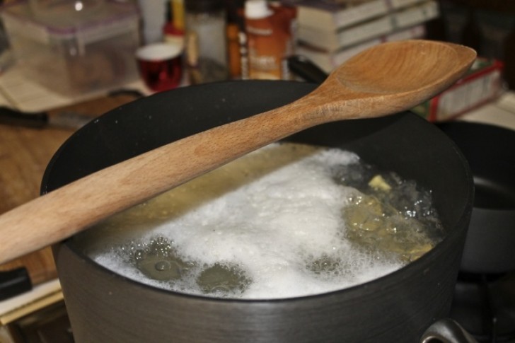 9. Para no hacer salir el agua hirviendo de la olla, apoyar un mezclador de madera sobre el borde.