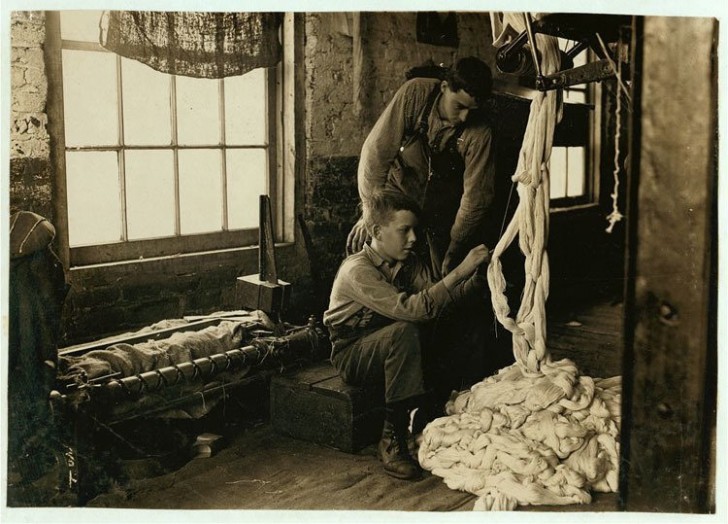 Un jeune garçon, employé de Clyde Cotton Mill à Newton, en Caroline du Nord, alors qu'il travaille le coton.