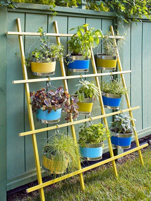 11. A vertical wooden grid with plant pots hanging from hooks.