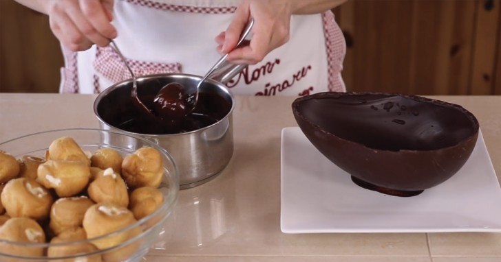 6. Iniziate ad assemblare il profiterol immergendo i bignè nella cioccolata sciolta.