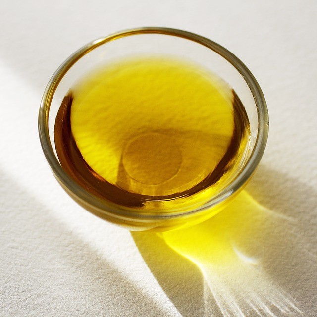 Una ciotola trasparente contiene olio di oliva