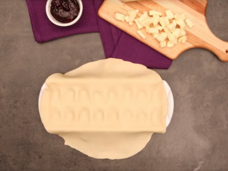 1 - Adagiate un rotolo di pasta sulla vaschetta per il ghiaccio vuota e spingete con le dita la pasta nelle cavità.