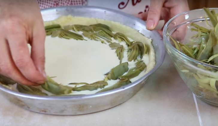 Pour the mixture on the pastry dough base and place the sliced artichokes on the cream in a clockwise circular pattern.