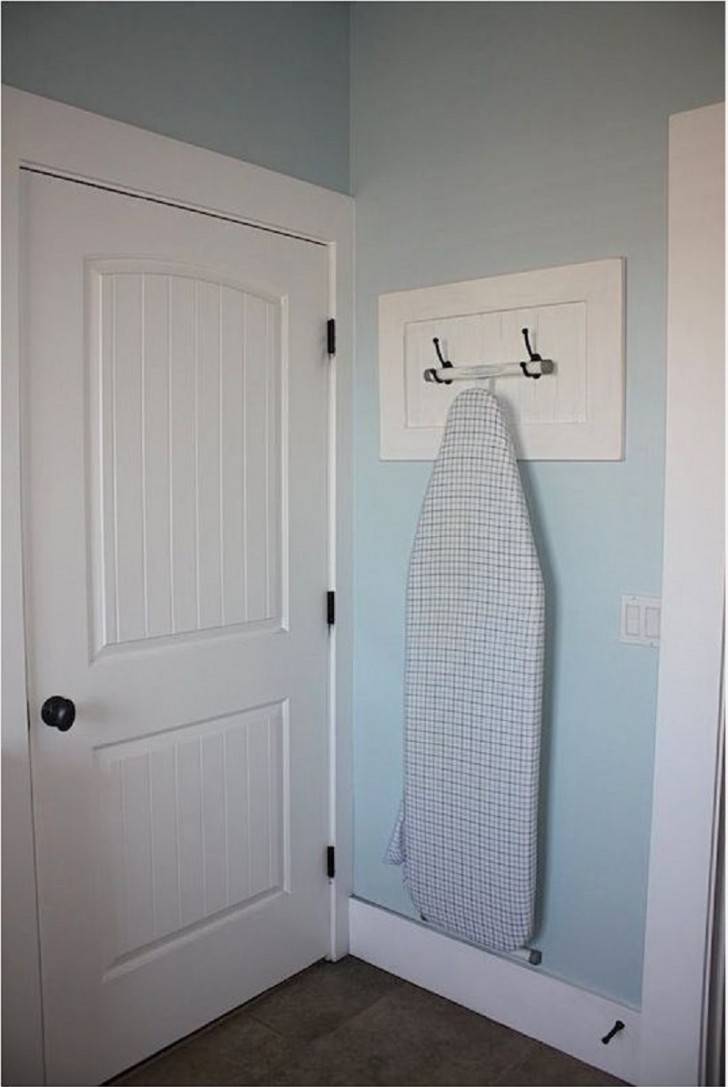 5. Two hooks are enough to hide the ironing board behind a door.