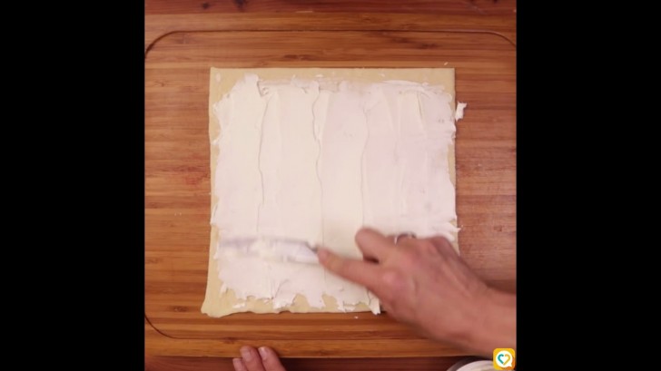 Dérouler la pâte et étaler le fromage crémeux.
