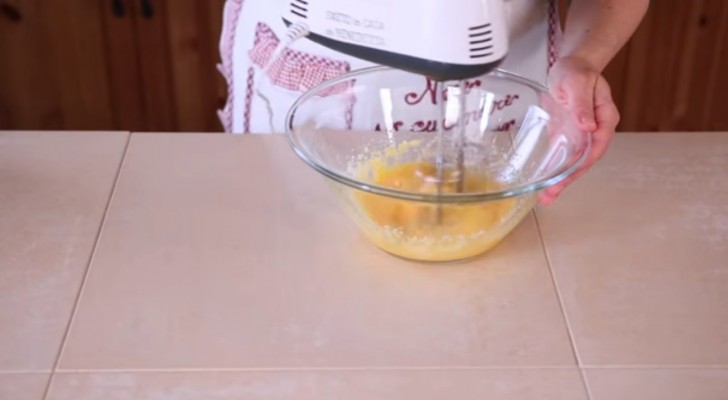2. Romper los huevos, agregar la sal, el azucar, el queso y comenzar a mezclar.