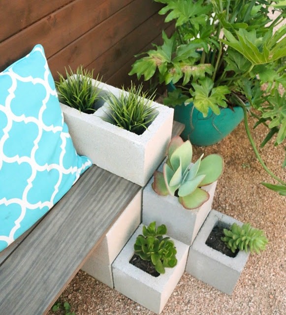 5. Here is an interesting way to use concrete cement blocks! In addition to creating a support for a bench, they are also great containers for seedlings.