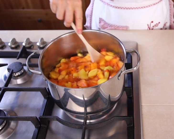 2. Dans une grande casserole, versez 1 litre d'eau dans une grande casserole et ajoutez 300 g de sucre. Allumez le feu pour faire fondre le sucre, puis versez les pêches.