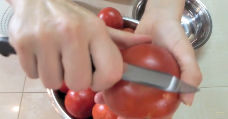 2. Avec le bord lisse de la lame du couteau, appuyez sur la tomate en reproduisant le geste que vous faites avec un économe. Cela vous permettra de supprimer la peau plus facilement.