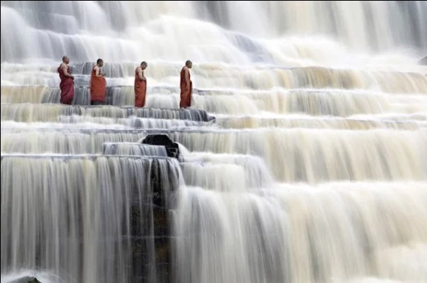 Monks meditate at Pongour Falls in Vietnam