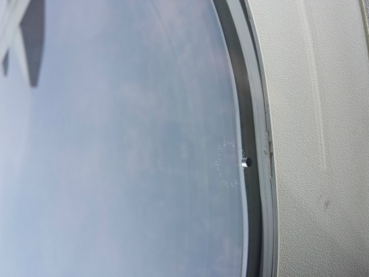 The tiny hole at the bottom or on the side of an airplane window
