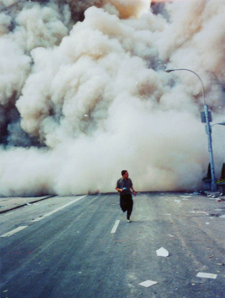 8. Un uomo tenta di salvarsi dalla nube di fumo che in pochi secondi invade le strade. 