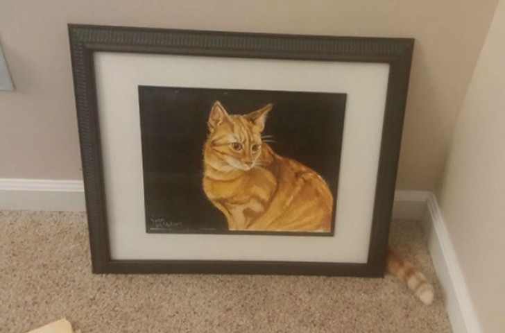 En katt... Gömd bakom sitt trogna porträtt!